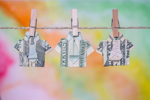 Origami shirt made of dollar banknote on hanging colorful
background dollar bills hanging on a rope close up