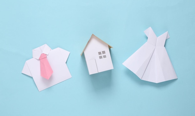 Foto origami trouwjurk en overhemd met stropdas huismodel op blauwe achtergrond