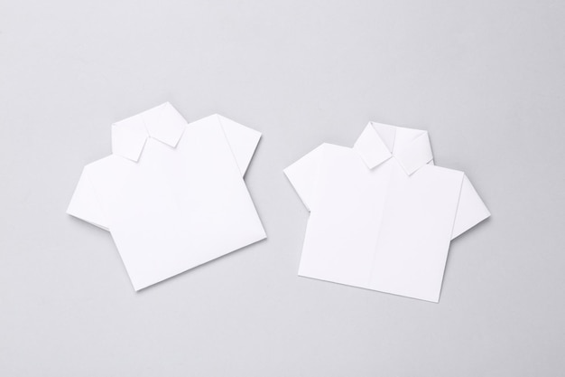 Origami white paper shirt on gray background