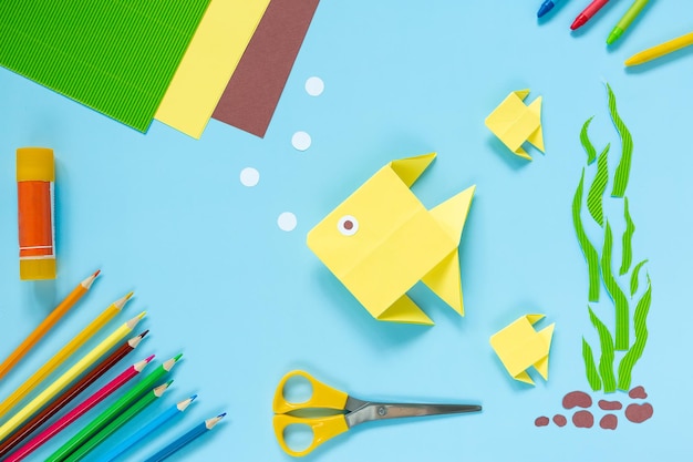 Origami yellow fish on a blue background childrens craft