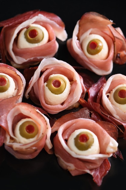 Original Halloween snacks. Eyeballs cooked from ham with mozzarella, olives stuffed with red pepper