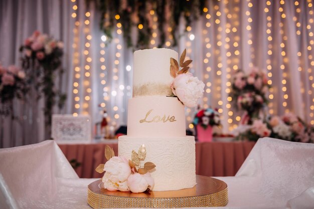 An original high wedding cake decorated with flowers and leaves 3813