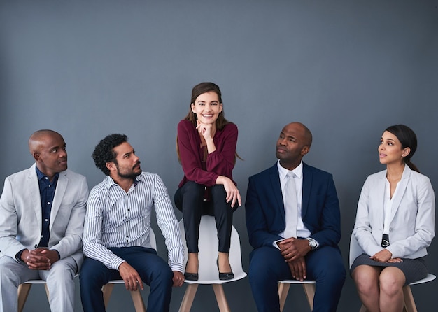 Foto l'originalità ti farà risaltare per l'intervista ripresa in studio di un gruppo di uomini d'affari in attesa in fila su uno sfondo grigio