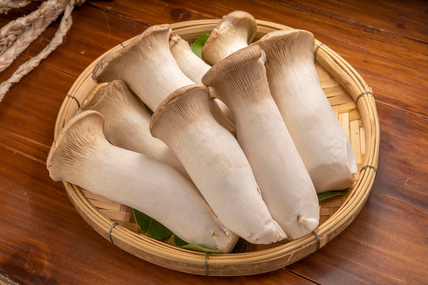 Photo oringi mushroom or japanese mushrooms on bamboo basket.