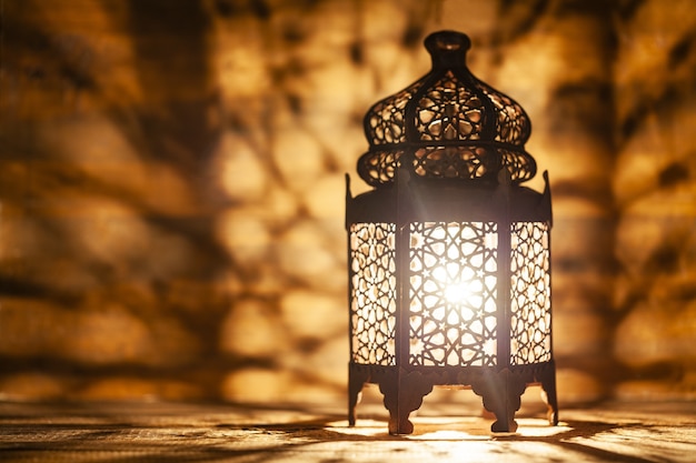 Ornamental Arabic lantern with burning candle glowing