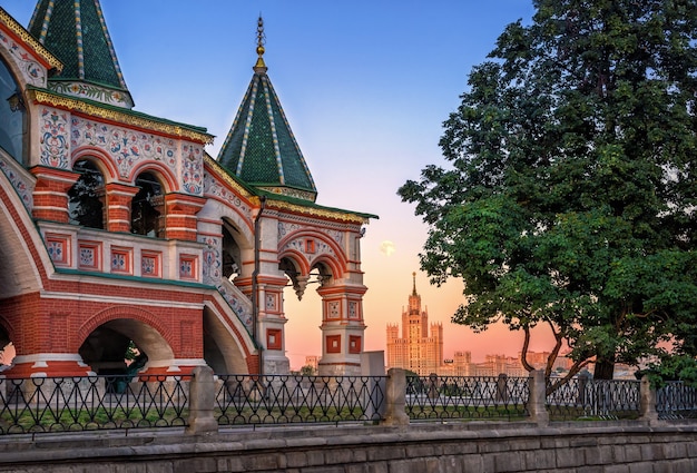 Photo ornate porch of the st. basil cathedral in moscow and the house on kotelnicheskaya embankment in the gentle light of a evening