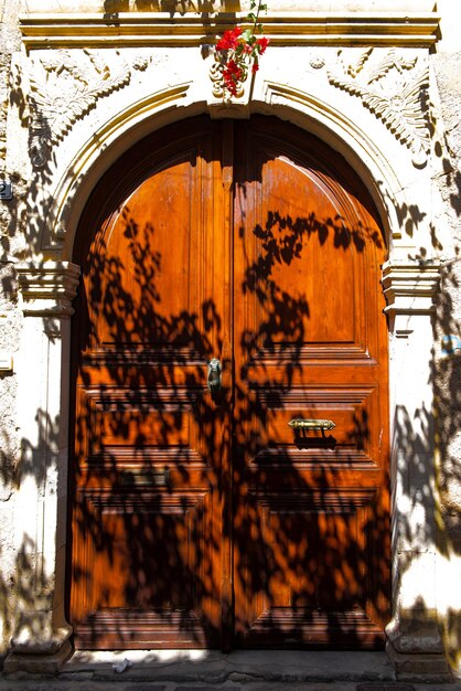 日差しが差し込む半影にある、凝った細工が施された木製のドア