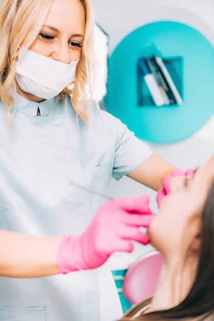 Orthodontist checking girl's dental braces