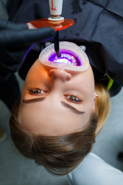 歯科矯正医は患者の歯に金属製のブレースを付けます。歯科矯正歯科治療。高品質の写真