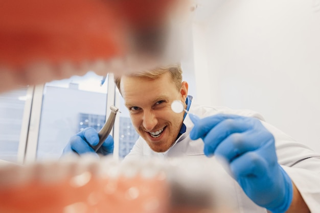 Orthodontist with dental tools examining patient teeth
