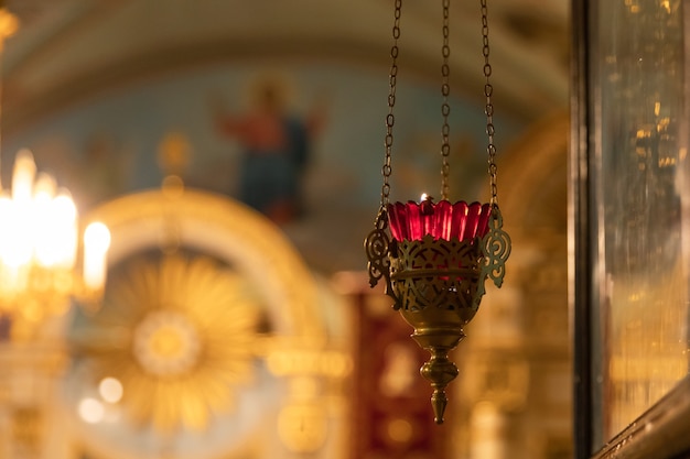 Orthodox church christianity festive interior decoration with burning candles and icon in traditiona...