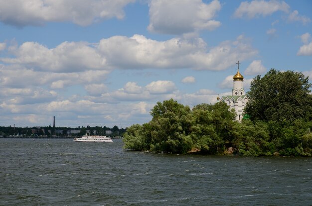 Orthodox church on a river island, and sailing ship