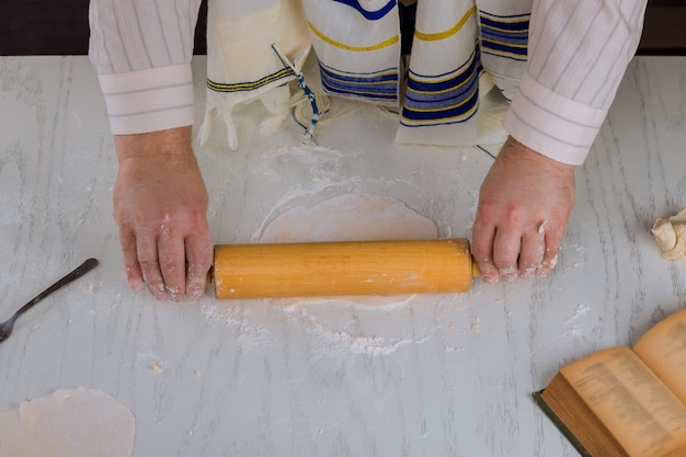 정통 유대인 남자는 베이킹을 위해 손으로 만든 평평한 정결 한 matzah를 준비합니다.