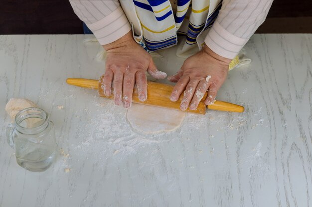 유월절을 위해 Matzos를 위해 반죽을 굴리고 유대인 휴일을 위해 오븐에 넣는 정통 유대인