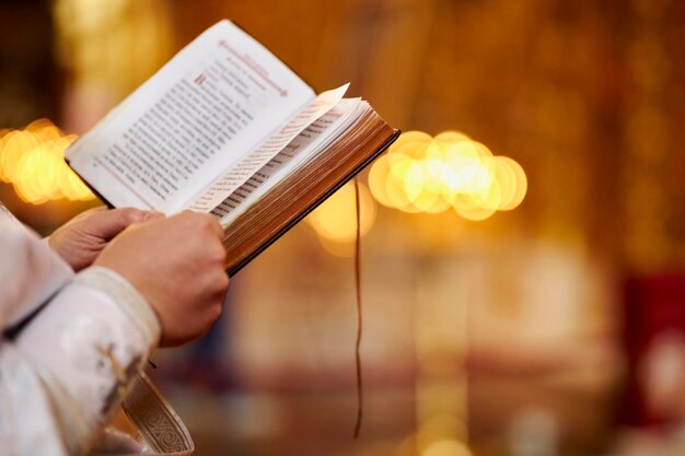 Photo an orthodox priest holds a bible in his hands a priest with a bible church ritual