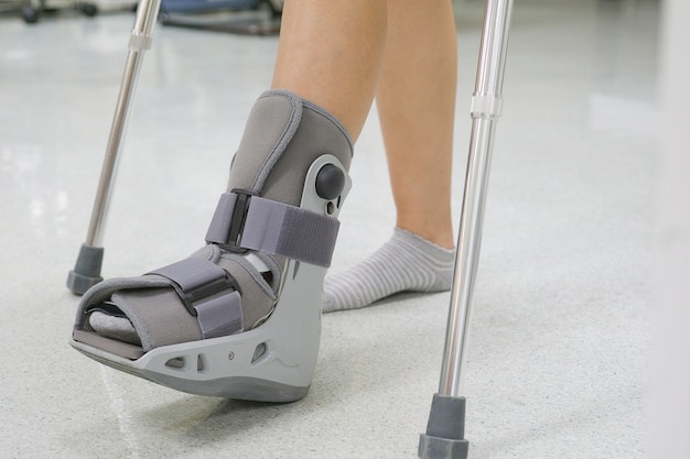 Photo orthopaedic boot and crutch to a patient. medical orthopedic concept.