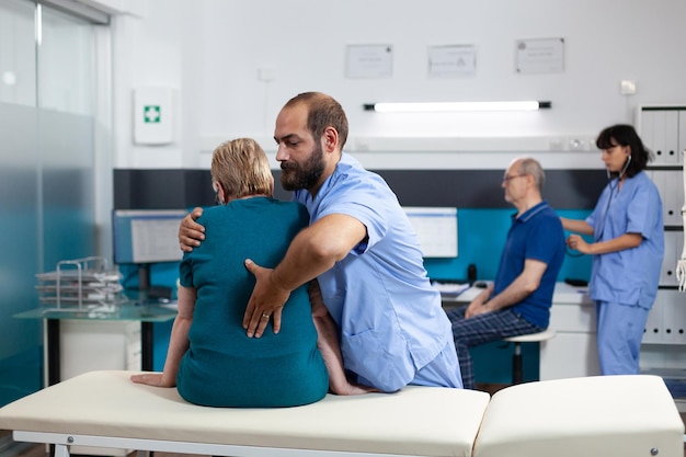 Orthopedic assistant relieving pressure from back bones of aged\
patient for physiotherapy. chiropractor giving assistance and\
helping elder woman with spinal cord pain for physical\
recovery