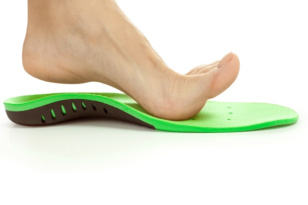 Orthopedic insole and female leg above it