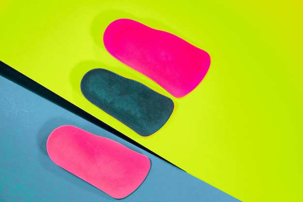 Orthopedic insoles are lined up on a wooden surface samples of different orthopedic insoles insoles with a variety of coating