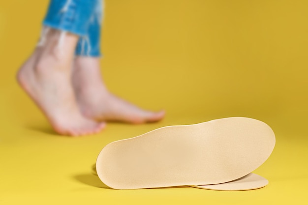 Photo orthopedic insoles for shoes on a colour background. foot care