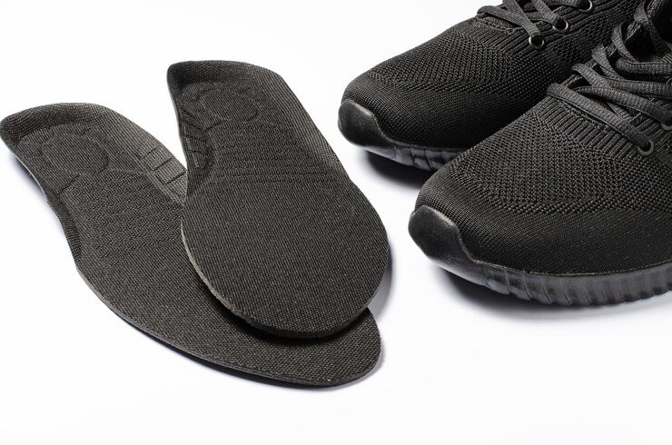 Orthopedic insoles and sports sneakers White background The concept of prevention of foot diseases