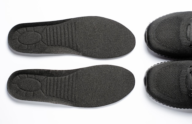 Foto solette ortopediche e sneakers sportive sfondo bianco il concetto di prevenzione delle malattie del piede