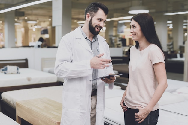 Photo orthopedics consultant helps her choose the right mattress.