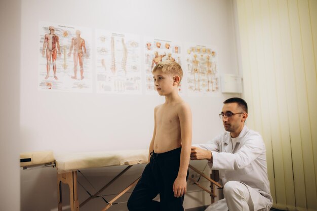 Orthopedist onderzoekt kinderen terug in de kliniek Scoliose behandeling