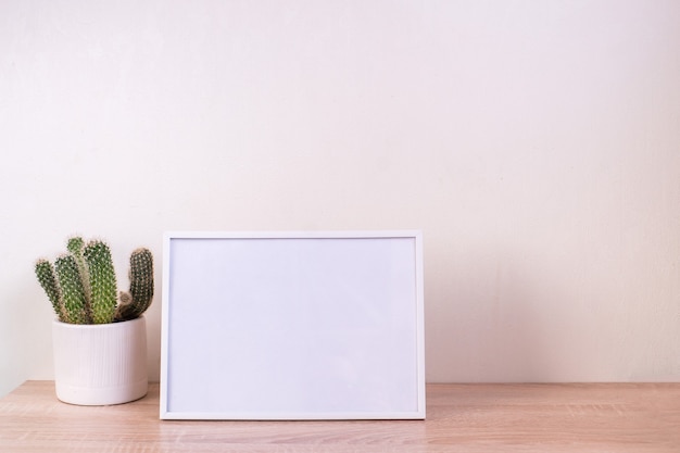 Photo ortrait white picture frame mockup on wooden table. modern ceramic vase with gypsophila. white wall background. scandinavian interior.