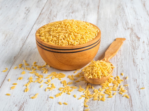 Orzo (risoni) pasta in wooden bowl.