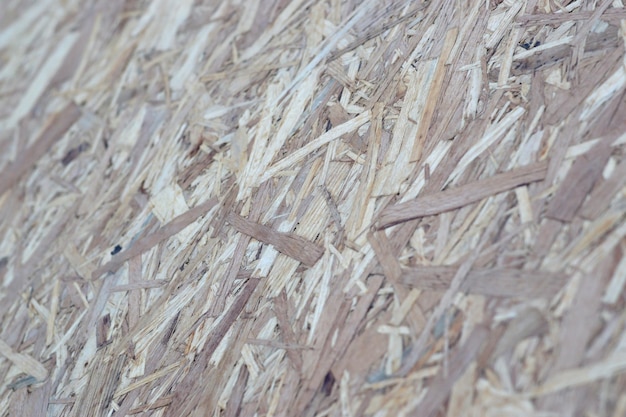 OSB-platen gemaakt van bruine houtsnippers geschuurd in een houten ondergrond Bovenaanzicht van OSB-houtfineer ondergrond
