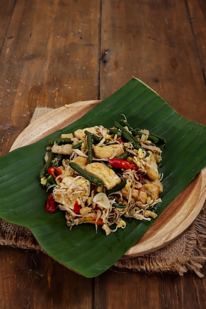 Oseng tahu kacang panjang of roergebakken kok van gesneden tofu en kousenband met kruiden