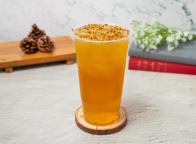 Osmanthus Oolong ice Tea served in disposable glass isolated on background top view of taiwan drink