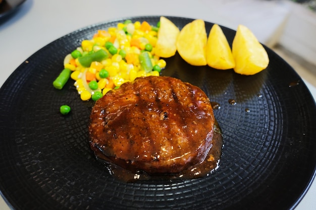 Ossenhaasbiefstuk met ronde vorm en aardappelpartjes en groenten