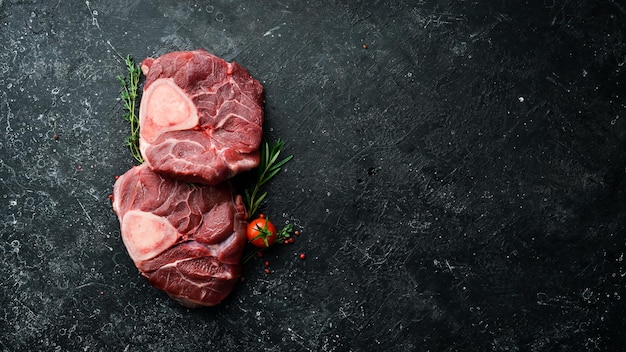 Osso buco Kalfsbiefstuk met rozemarijn en kruiden Op een zwarte achtergrond Bovenaanzicht