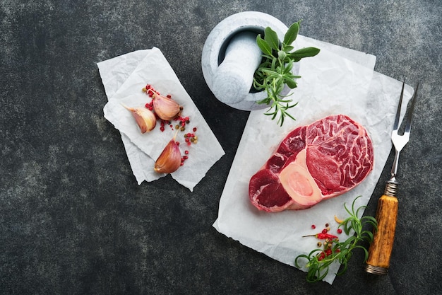 Osso Buco raw steak meat Barbecue meat Raw fresh cross cut veal shank and seasonings pepper rosemary thyme and salt on dark background Beef Leg Slice Italian menu Top view