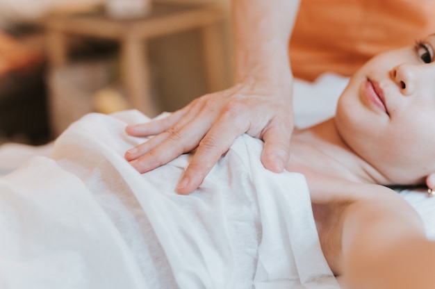 Osteopaat handen doet therapie voor meisje. pediatrische osteopathie behandelsessie. alternatief medicijn