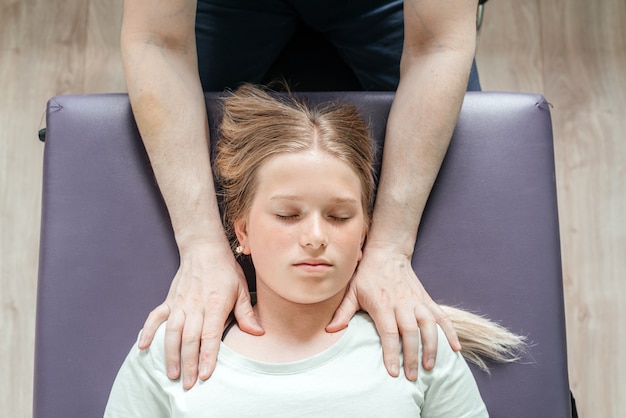 Photo ostheopatic treatment of a girl patient using cst gentle hands-on technique, central nervous system tension relieve