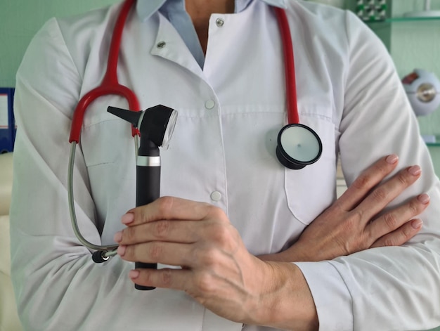 Otolaryngologist ENT doctor holds otoscope in hands