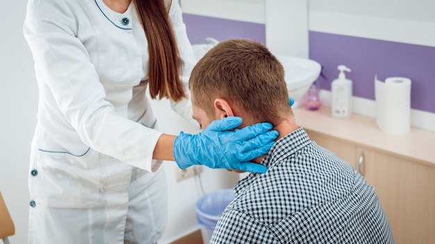 Otolaryngologist examines man's throat.