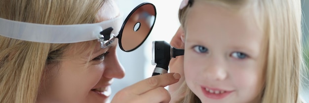 Photo otorhinolaryngologist examines the ear of a little girl