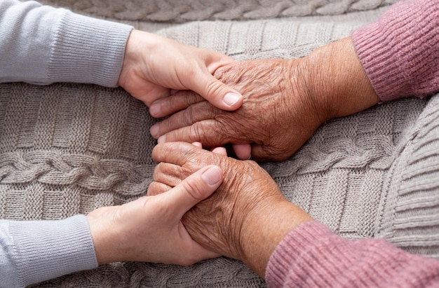 Foto oud en jong hand in hand ouderdomsondersteuning helpt oude mensen