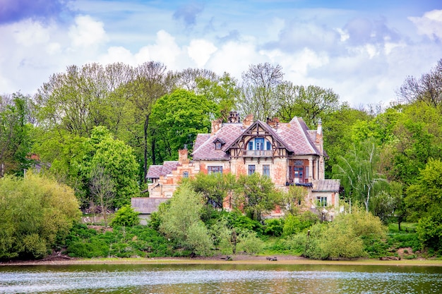 Oud gebouw aan de oevers van de rivier op een zonnige zomerdag