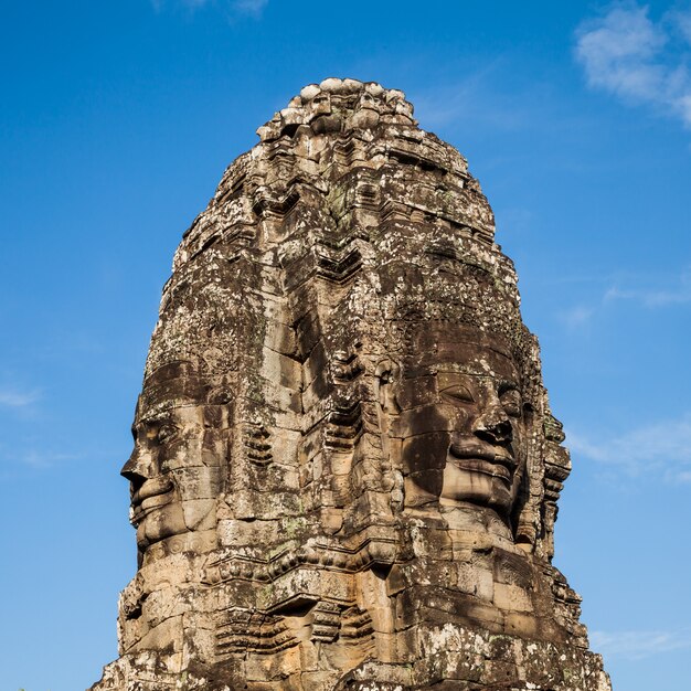 Oud gezicht van kasteel Bayon op blauwe hemel.