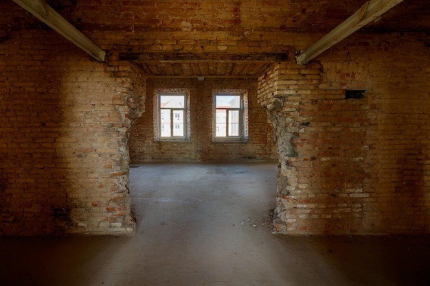 Oud grungebinnenland met een vernietigde bakstenen muur