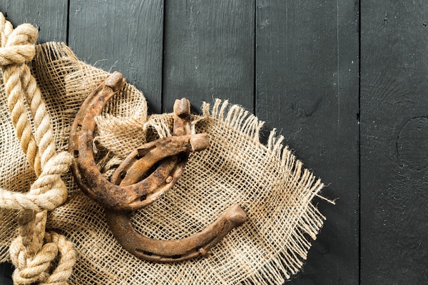 Oud hoefijzer en touw op houten planken