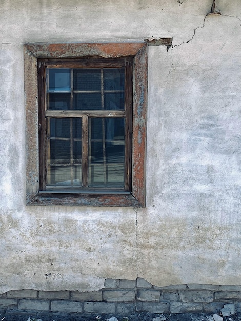 Oud houten raam aan de muur van een oud huis in het dorp