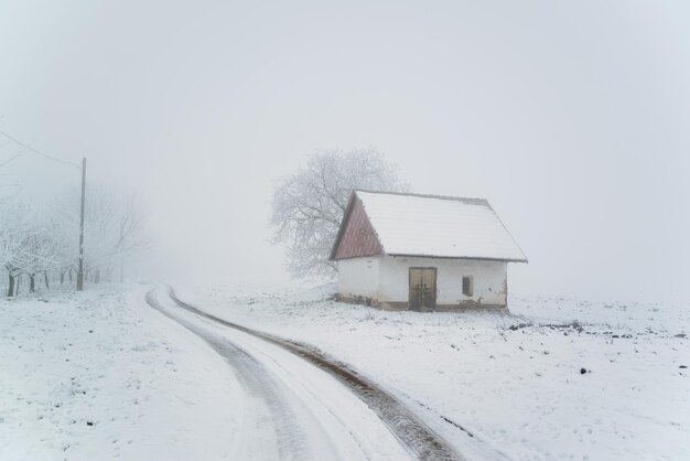 Oud huis op besneeuwd winterveld