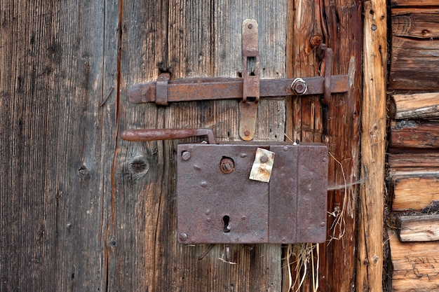 Oud ijzerhoudend slot op de houten deuren van schuur