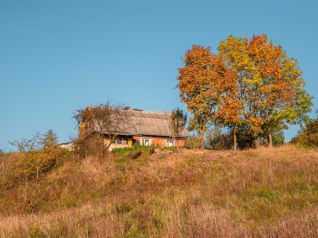 Oud landelijk huis op een de herfstheuvel. Plattelands leven.